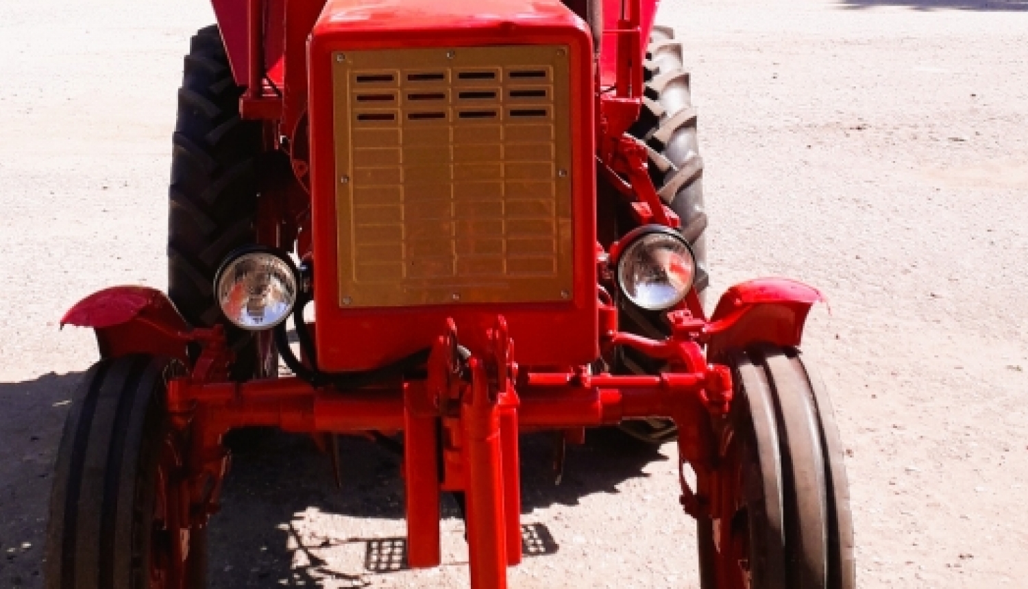 Sarkans, senlaicīgs traktors no priekšas
